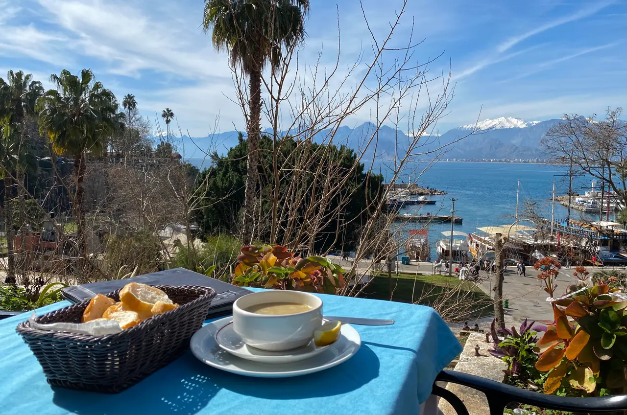 Lentil soup and fresh bread on a terrace overlooking Antalya harbour and the mountains