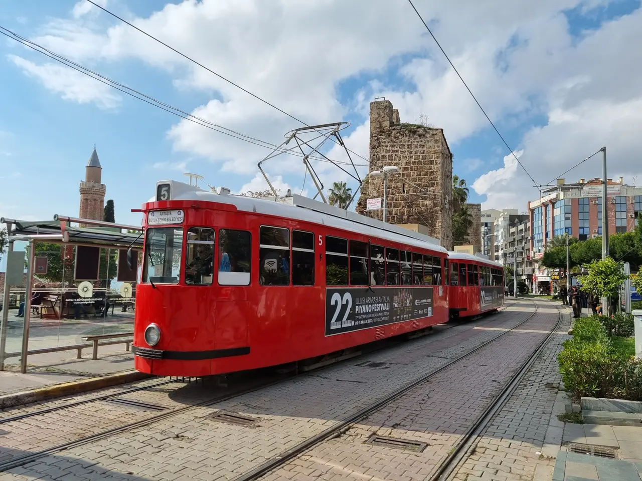 Antalya's red nostalgic tram beside the old town walls